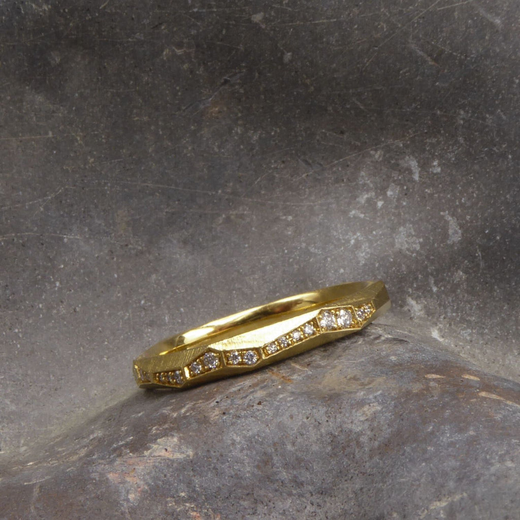ein-ganz-schmaler-ring-aus-unserer-ecken-und-kanten-kollektion-mit-vielen-unregelmaessigen-facetten-beziehungsweise-polygonen-flaechen-der-ring-ist-ca-zweieinhalb-millimeter-breit-und-besteht-aus-gelbgold-er-ist-auch-in-fairtrade-gold-erhaeltlich-auf-vielen-facetten-sind-vollflaechig-brillanten-eingefasst-so-dass-sich-ein-umlaufendes-band-aus-diamanten-ergibt-ein-design-ehering-oder-verlobungsring-der-nicht-von-der-stange-ist-die-ringe-werden-von-hand-in-unserer-goldschmiede-in-frankfurt-am-main-angefertigt