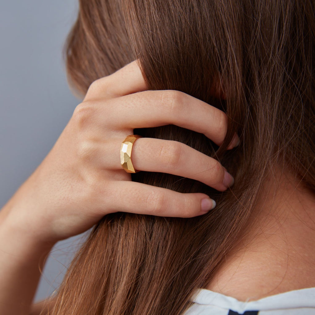 ein-an-der-hand-getragener-ring-aus-unserer-ecken-und-kanten-kollektion-mit-vielen-unregelmaessigen-facetten-beziehungsweise-polygonen-flaechen-die-ringe-sind-ca-sechseinhalb-millimeter-breit-sie-bestehen-aus-gelbgold-design-trauringe-oder-partnerringe-die-einfach-besonders-sind-die-ringe-werden-von-hand-in-unserer-goldschmiede-in-frankfurt-am-main-angefertigt-alexandra-baum-schmuck