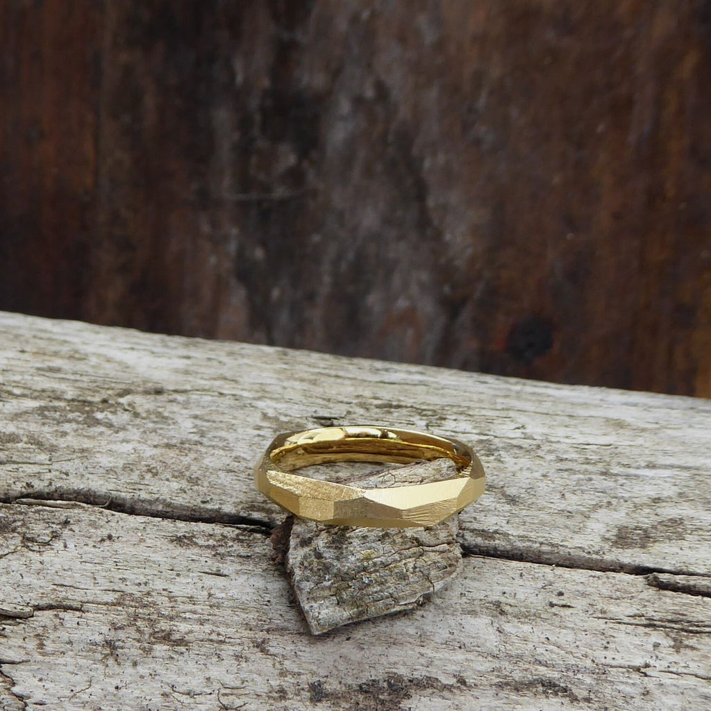 ein-schmaler-ring-mit-vielen-unregelmaessigen-facetten-beziehungsweise-polygonen-flaechen-der-ring-ist-ca-viereinhalb-millimeter-breit-und-besteht-aus-gelbgold-er-ist-auch-in-fairtrade-gold-erhaeltlich-die-ringe-werden-von-hand-in-unserer-goldschmiede-in-frankfurt-am-main-angefertigt-alexandra-baum-schmuck