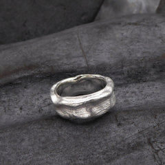 ein-ring-aus-sterling-silber-der-aus-einer-abgegossenen-schote-des-affenbrot-baums-besteht-im-vordergrund-sieht-man-sehr-gut-die-feine-struktur-der-schote-in-der-oberflaeche-ring-von-alexandra-baum-schmuck