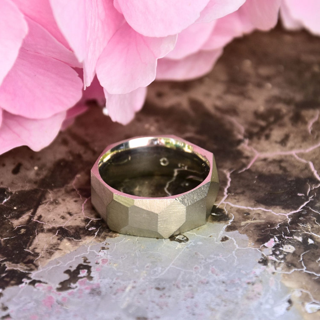 ein-breiter-auffaelliger-ring-mit-vielen-unregelmaessigen-facetten-oder-polygonen-flaechen-der-ring-ist-ca-achteinhalb-millimeter-breit-und-besteht-aus-palladiumweissgold-geeignet-als-trauring-oder-schmuckring-fuer-menschen-die-auffaellige-ringe-moegen-die-ringe-werden-von-hand-in-unserer-goldschmiede-in-frankfurt-am-main-angefertigt-und-sind-individuell-anpassbar-alexandra-baum-schmuck