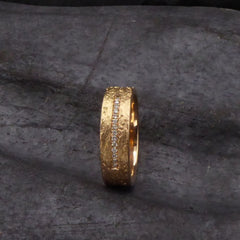 ein-breiter-trauring-mit-rinden-struktur-in-rosegold-mit-einer-linie-aus-vierzehn-diamanten-besetzt-von-alexandra-baum-schmuck-frankfurt