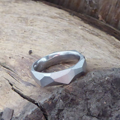 ein-breiterer-ring-mit-vielen-unregelmaessigen-facetten-beziehungsweise-polygonen-flaechen-der-ring-ist-ca-sechseinhalb-millimeter-breit-und-besteht-aus-platin-die-ringe-werden-von-hand-in-unserer-goldschmiede-in-frankfurt-am-main-angefertigt-und-sind-individuell-anpassbar-alexandra-baum-schmuck