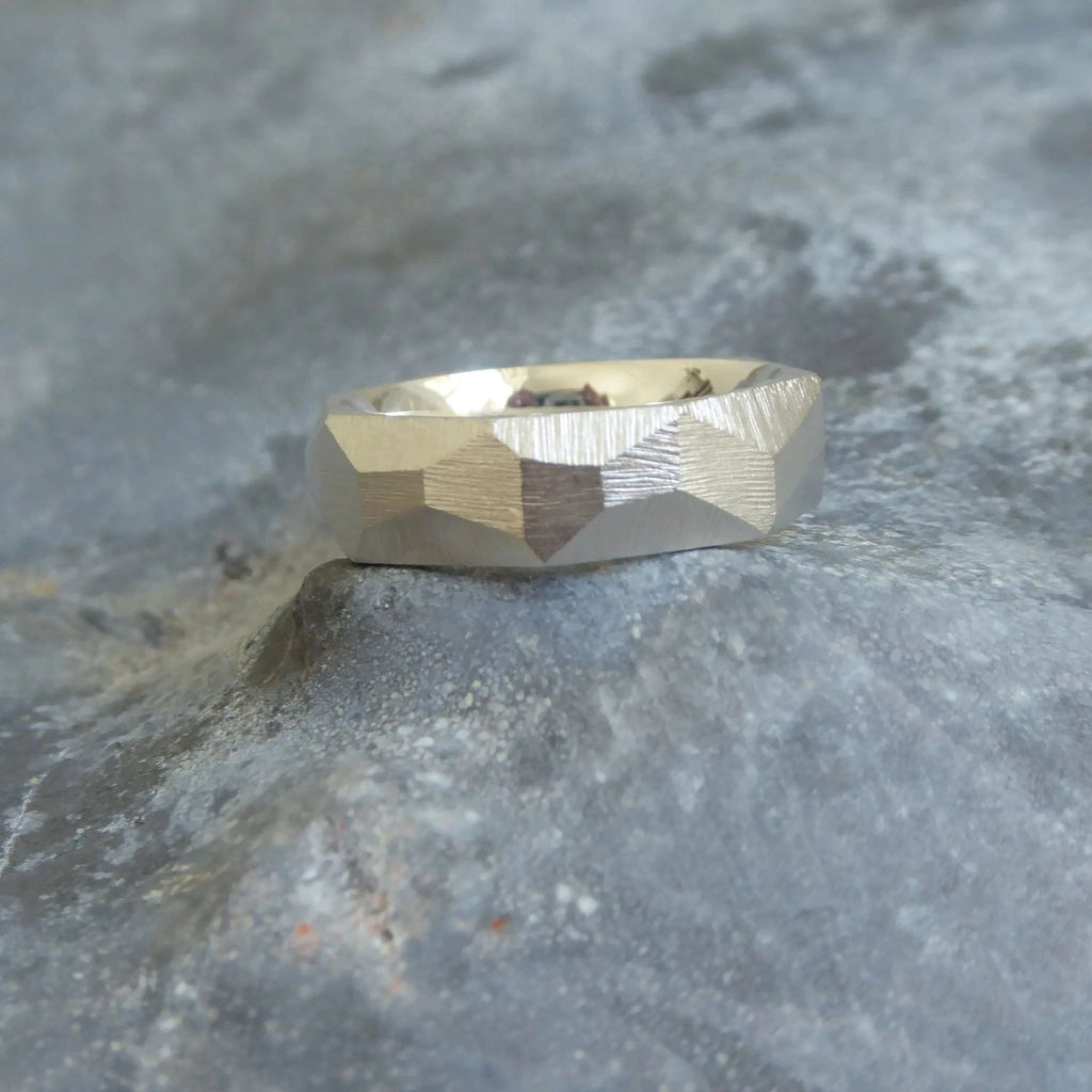 ein-breiterer-ring-mit-vielen-unregelmaessigen-facetten-beziehungsweise-polygonen-flaechen-der-ring-ist-ca-sechseinhalb-millimeter-breit-und-besteht-aus-recycling-sterling-silber-er-ist-auch-in-fairmined-silber-erhaeltlich-die-ringe-werden-von-hand-in-unserer-goldschmiede-in-frankfurt-am-main-angefertigt-und-sind-individuell-anpassbar-alexandra-baum-schmuck