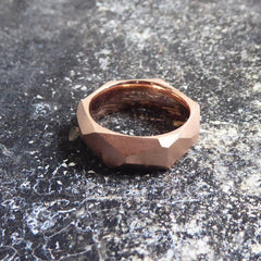ein-breiterer-ring-mit-vielen-unregelmaessigen-facetten-beziehungsweise-polygonen-flaechen-der-ring-ist-ca-sechseinhalb-millimeter-breit-und-besteht-aus-rotgold-geeignet-als-trauring-oder-schmuckring-die-ringe-werden-von-hand-in-unserer-goldschmiede-in-frankfurt-am-main-angefertigt-und-sind-individuell-anpassbar-alexandra-baum-schmuck