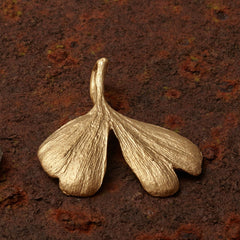 mittelgroßer-handgefertigter-ginkgo-anhänger-mit-feiner-struktur-von-echten-ginkgoblaettern-abgeformt-ohne-kette-in-sterling-silber-vergoldet-und-echtgold-aus-unserer-goldschmiede-in-frankfurt-auch-in-fairtrade-gold-erhaeltlich-geschwungene-form-mit-einem-schlitz-und-wellen-an-den-blattspitzen-ungefaehr-37-millimeter