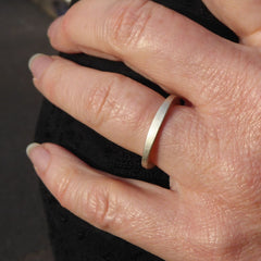 ein-am-finger-getragener-ring-mit-dem-namen-durch-dick-und-duenn-der-ring-besteht-aus-sterling-silber-die-form-ist-klassisch-aber-leicht-unregelmaessig-an-manchen-stellen-dicker-an-manchen-stellen-duenner-die-ringe-werden-von-hand-in-unserer-goldschmiede-in-frankfurt-am-main-angefertigt-das-modell-eignet-sich-auch-gut-als-ehering