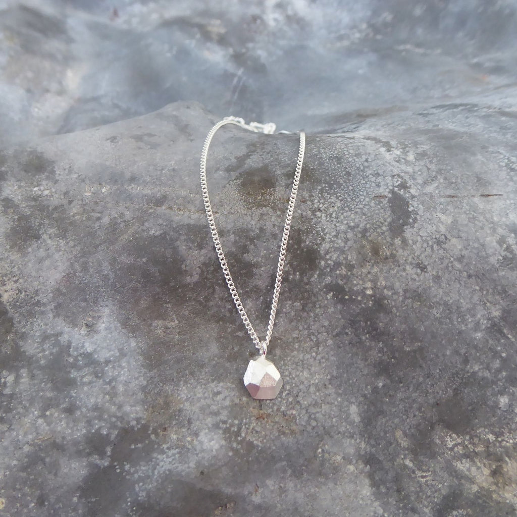 ecken-und-kanten-kette-mit-einem-kleinen-tropfenfoermigen-anhaenger-in-der-kleineren-variante-mit-unregelmaessigen-facetten-die-kette-besteht-aus-recycling-sterling-silber-als-verschluss-der-kette-ist-ein-karabiner-befestigt-den-man-auf-zwei-verschiedene-laengen-einhaken-kann-von-hand-gefertigt-in-unserer-goldschmiede-in-frankfurt-bockenheim