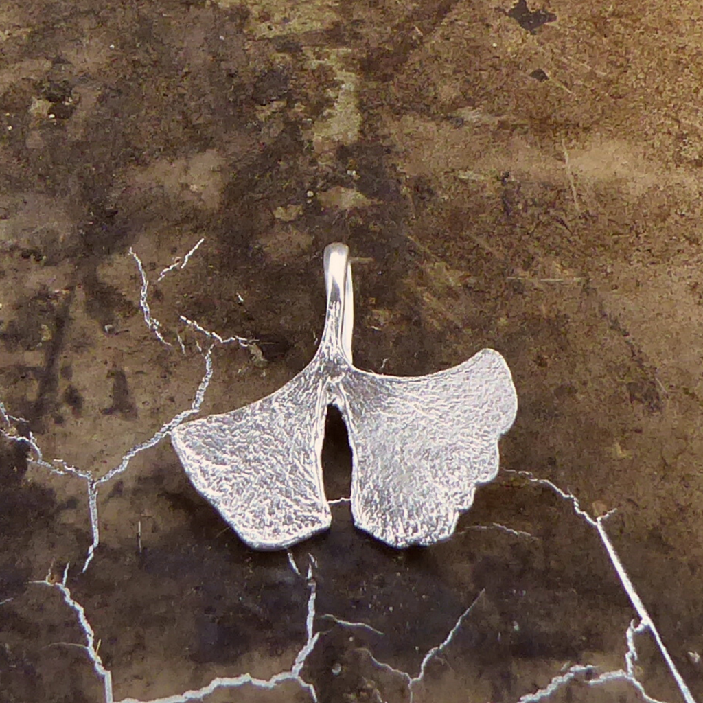 zarter-handgefertigter-ginkgo-anhänger-mit-feiner-struktur-von-echten-ginkgoblaettern-abgeformt-ohne-kette-in-sterling-silber-aus-unserer-goldschmiede-in-frankfurt-auch-in-fairmined-silber-erhaeltlich-zackige-geschwungene-form-mit-einem-schlitz