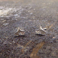 zarte-handgefertigte-mini-ginkgo-ohrringe-als-ohrstecker-mit-feiner-struktur-von-echten-ginkgoblaettern-abgeformt-mit-einem-schlitze-in-silber-aus-unserer-goldschmiede-in-frankfurt-auch-in-fairtrade-gold-erhaeltlich-groesse-ungefaehr-acht-millimeter
