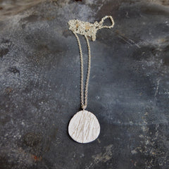 gras-anhaenger-kette-mit-einem-eirigen-anhaenger-mit-der-struktur-von-abgeformtem-gras-auf-dem-bild-ist-die-groessere-variante-zu-sehen-die-kette-besteht-aus-recycling-sterling-silber-als-verschluss-der-kette-ist-ein-karabiner-befestigt-den-man-auf-zwei-verschiedene-laengen-einhaken-kann-nachhaltiger-schmuck-von-hand-gefertigt-in-unserer-goldschmiede-in-frankfurt-bockenheim-alexandra-baum-schmuck