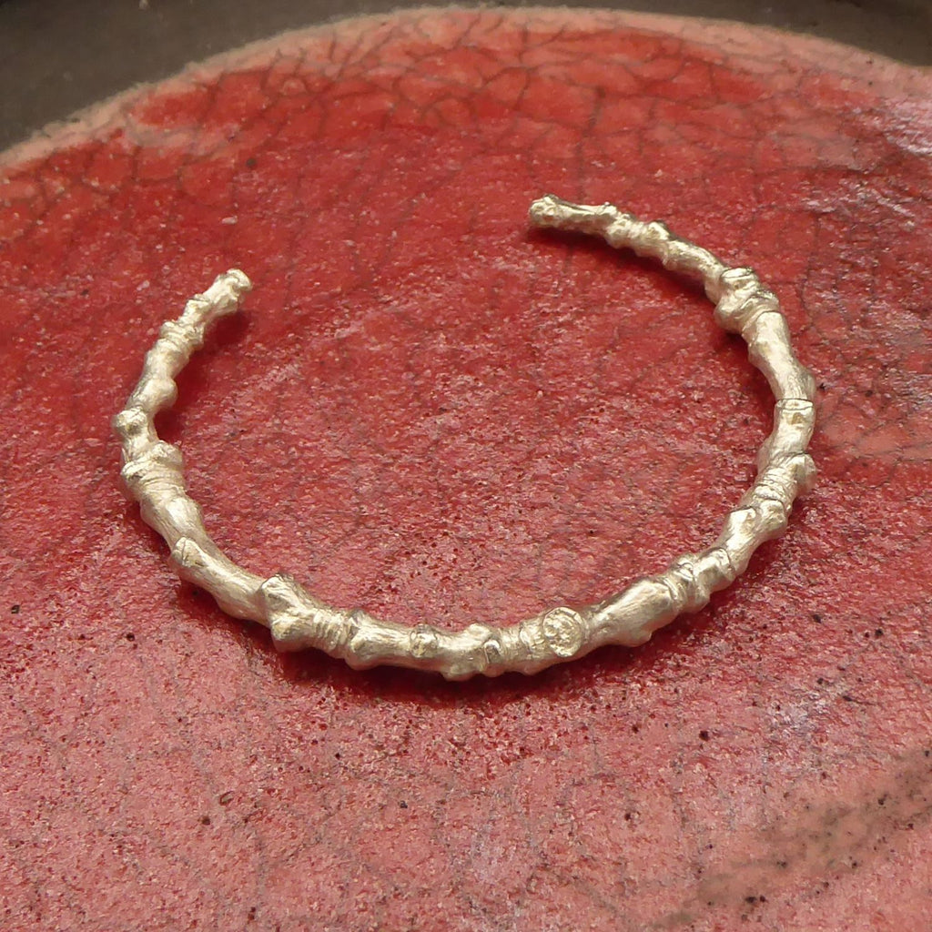 schlichter-handgefertigter-kirschast-armreif-mit-feiner-struktur-von-echten-aestchen-abgeformt-mit-kleinen-knubbeln-in-sterling-silber-aus-unserer-goldschmiede-in-frankfurt-auch-in-fairtrade-gold-oder-fairmined-silber-erhaeltlich-die-groesse-ist-leicht-anpassbar-alexandra-baum-schmuck
